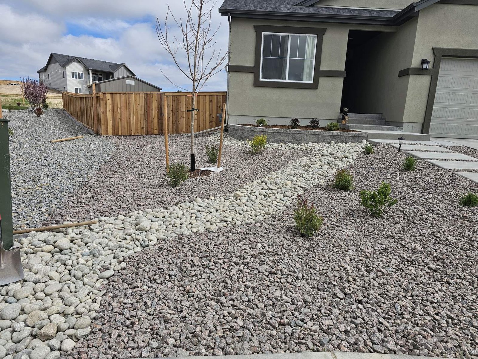 Water-wise front-yard rock landscaping with a dry creek bed at a new Colorado Springs home
